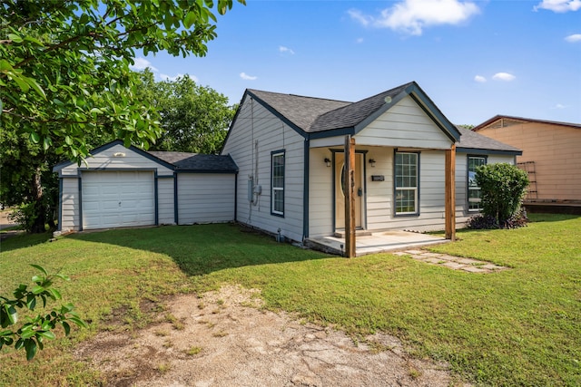 view of front of house featuring a front lawn, an outbuilding, and a garage