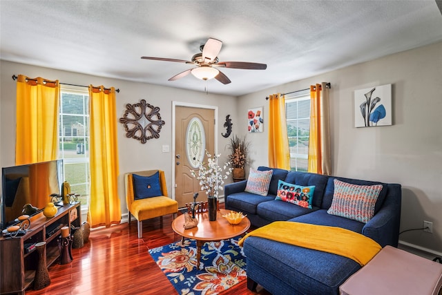 living room featuring dark wood-type flooring, a textured ceiling, a healthy amount of sunlight, and ceiling fan