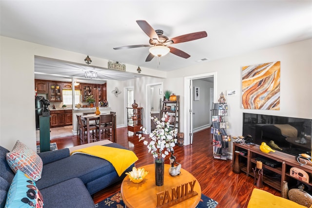 living room featuring ceiling fan and dark hardwood / wood-style floors