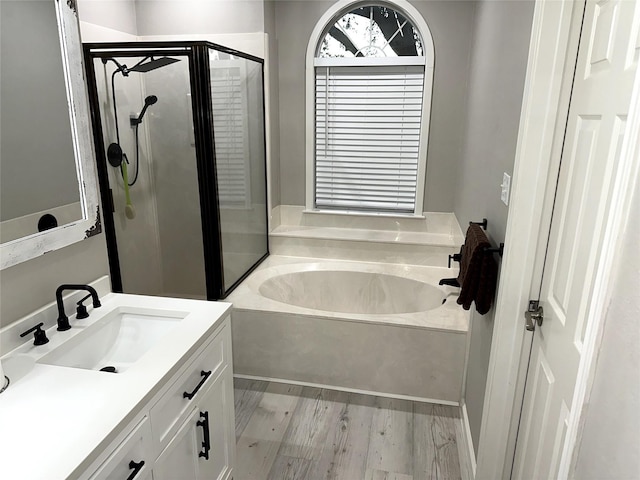 bathroom featuring shower with separate bathtub, vanity, and hardwood / wood-style flooring