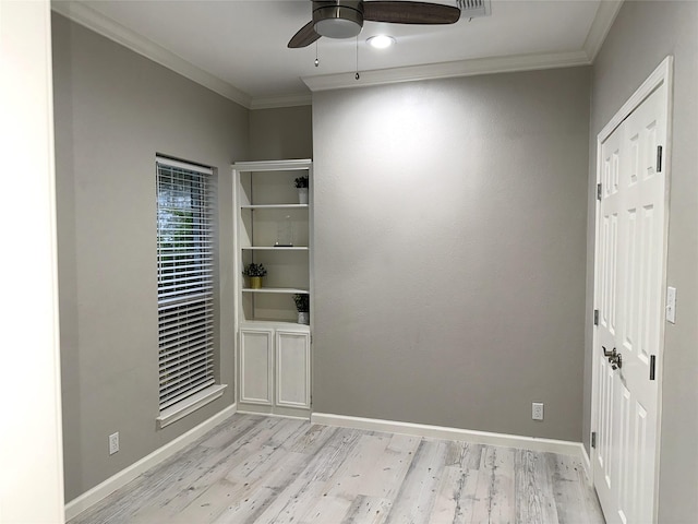 empty room featuring ceiling fan, light wood-type flooring, and crown molding