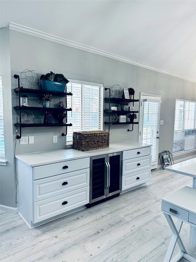 bar featuring a healthy amount of sunlight, white cabinetry, wine cooler, and light hardwood / wood-style flooring