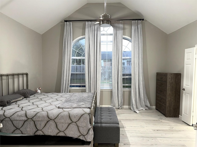 bedroom featuring ceiling fan, light hardwood / wood-style floors, and lofted ceiling