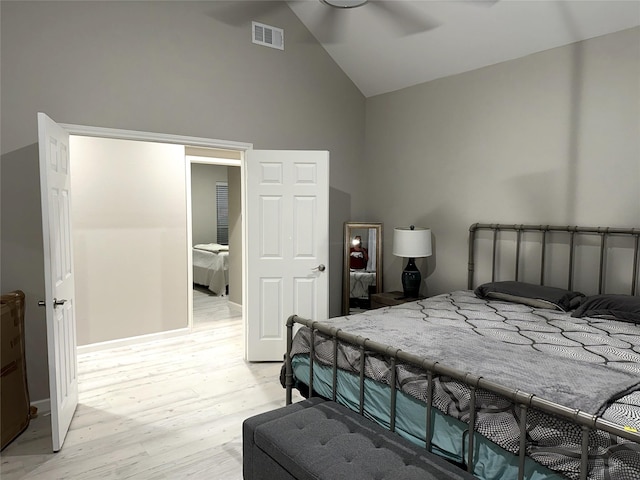 bedroom featuring light hardwood / wood-style floors, high vaulted ceiling, and ceiling fan