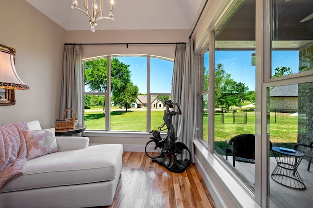 sunroom featuring vaulted ceiling, an inviting chandelier, and a wealth of natural light