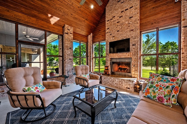 sunroom with lofted ceiling, plenty of natural light, and an outdoor brick fireplace