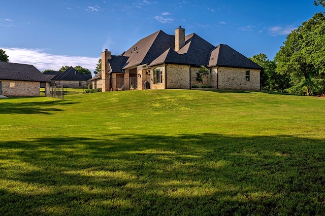 rear view of house featuring a yard