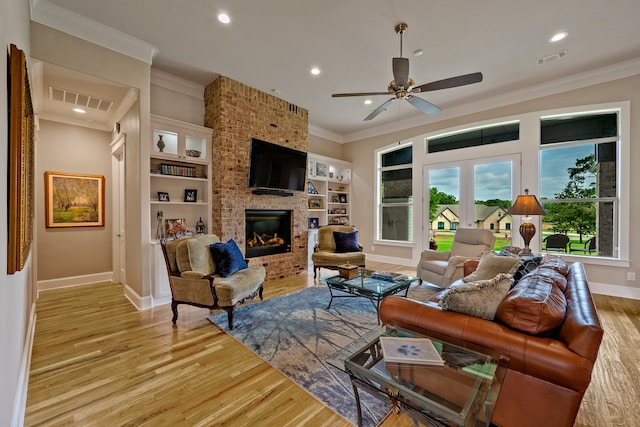 living room with a fireplace, ornamental molding, light hardwood / wood-style flooring, and ceiling fan