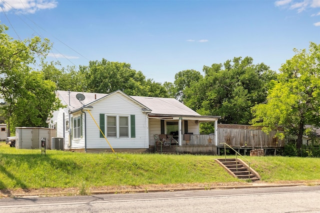 view of front of house featuring central AC and a front yard