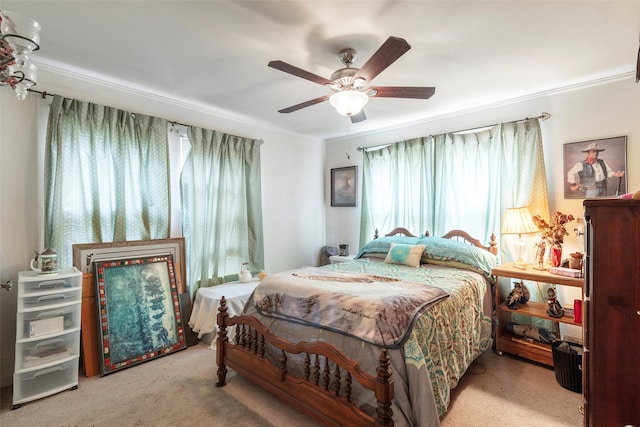 carpeted bedroom featuring ceiling fan and crown molding