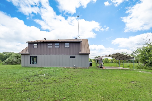 back of property featuring a lawn and a carport