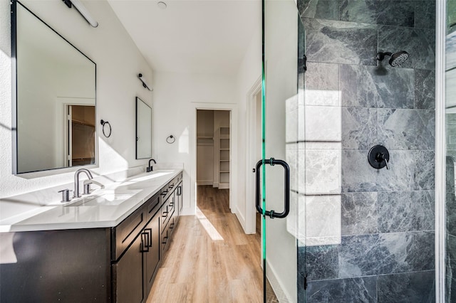 bathroom with an enclosed shower, vanity, and wood-type flooring