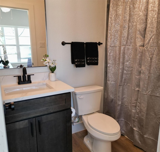 bathroom with toilet, wood-type flooring, and vanity