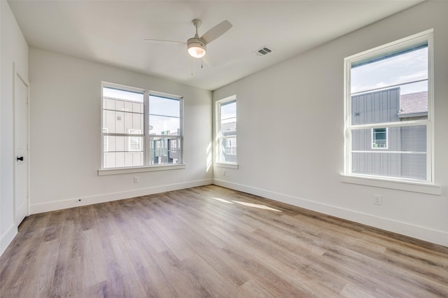 unfurnished room with ceiling fan, light wood-type flooring, and plenty of natural light