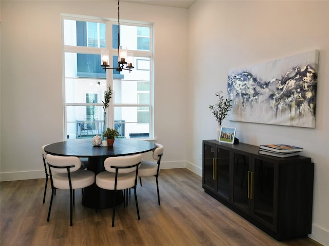 dining space featuring wood-type flooring and a notable chandelier