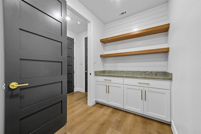 bar featuring white cabinetry and light wood-type flooring