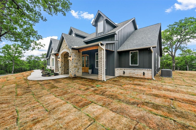 view of side of property featuring central AC unit and a lawn