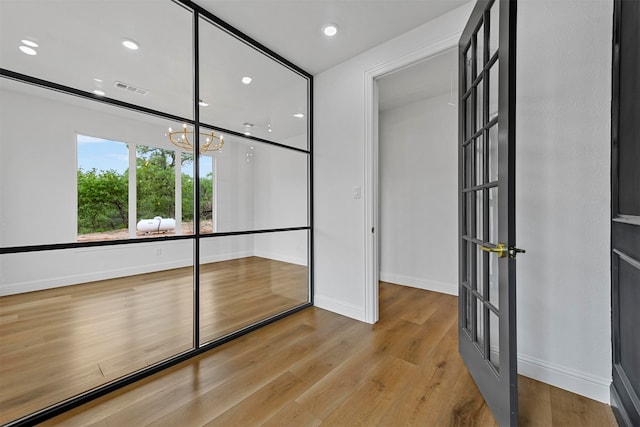 interior space with light wood-type flooring and an inviting chandelier