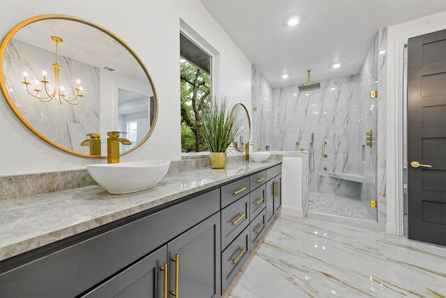 bathroom with a shower with door, vanity, and an inviting chandelier