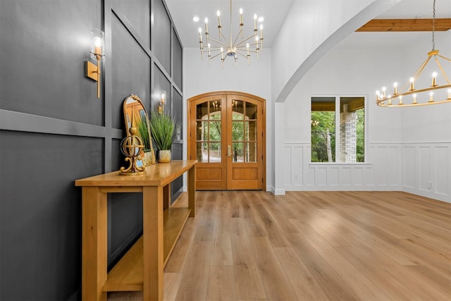 entryway with plenty of natural light, an inviting chandelier, and french doors