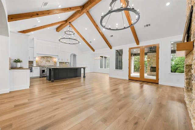 living room featuring french doors, light hardwood / wood-style flooring, beamed ceiling, high vaulted ceiling, and a notable chandelier