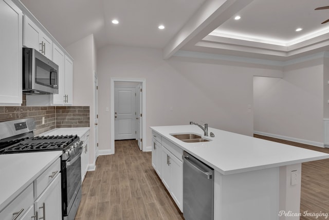 kitchen with appliances with stainless steel finishes, sink, a center island with sink, and white cabinets