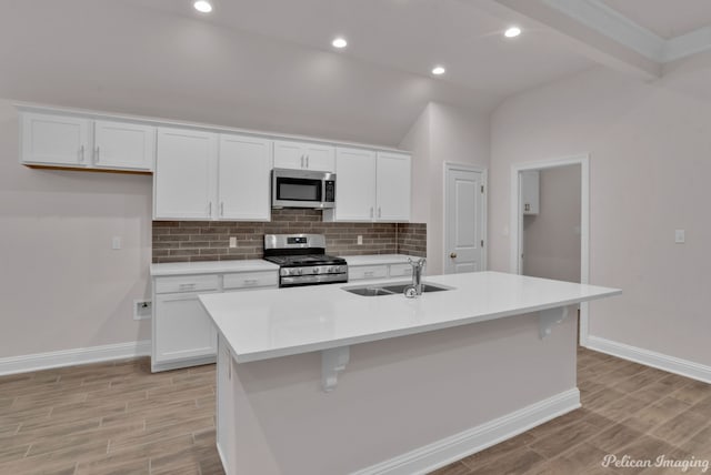 kitchen featuring a kitchen island with sink, stainless steel appliances, white cabinetry, and sink