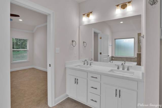 bathroom featuring vaulted ceiling, crown molding, vanity with extensive cabinet space, and dual sinks