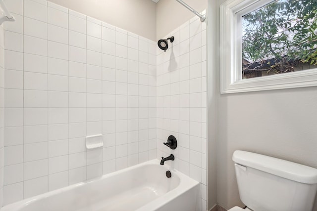 bathroom featuring toilet and tiled shower / bath