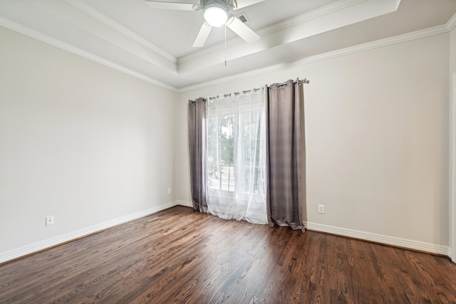 unfurnished room featuring a raised ceiling, ceiling fan, dark wood-type flooring, and ornamental molding