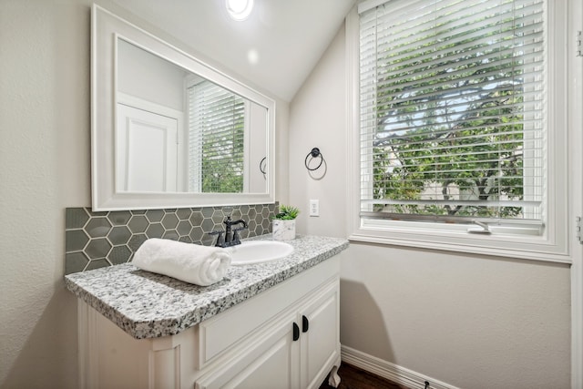 bathroom with vanity, backsplash, and a healthy amount of sunlight