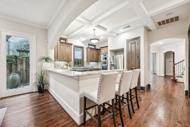 kitchen featuring dark wood-type flooring, tasteful backsplash, stainless steel fridge with ice dispenser, kitchen peninsula, and a breakfast bar