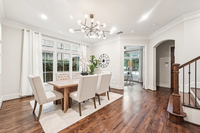 dining area featuring ornamental molding, dark hardwood / wood-style floors, a healthy amount of sunlight, and a chandelier