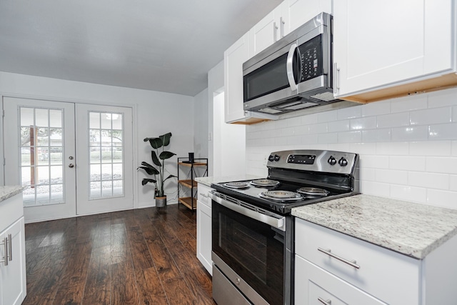 kitchen featuring tasteful backsplash, white cabinetry, dark wood-type flooring, stainless steel appliances, and french doors