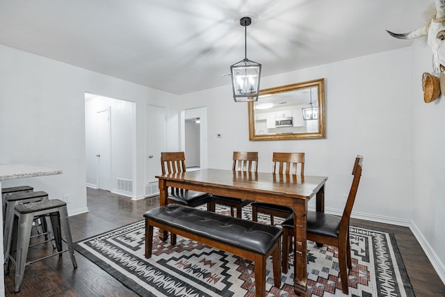 dining area featuring dark hardwood / wood-style floors and a chandelier