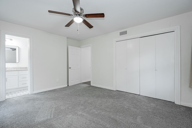 unfurnished bedroom with connected bathroom, ceiling fan, carpet flooring, and a closet