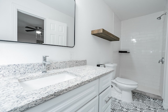 bathroom featuring ceiling fan, toilet, vanity, tiled shower, and tile floors