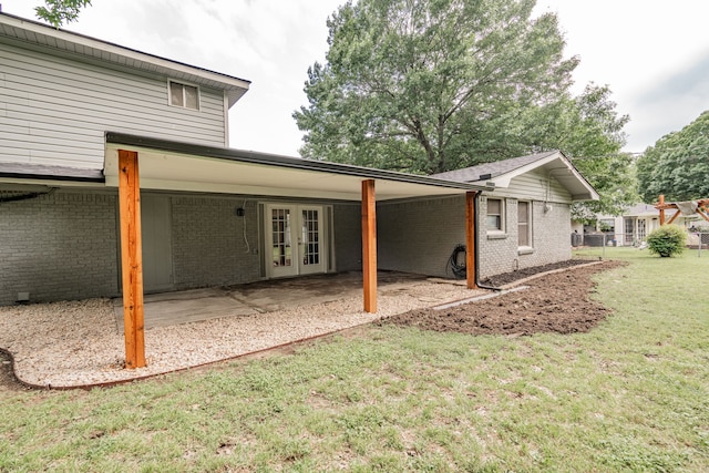 back of house with french doors, a patio, and a lawn