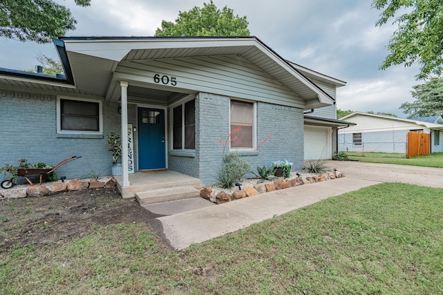 bungalow-style house with a porch, a front lawn, and a garage