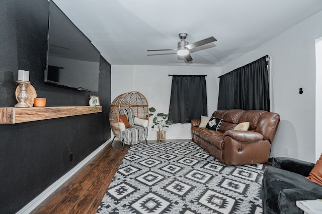 living room featuring ceiling fan and dark hardwood / wood-style floors