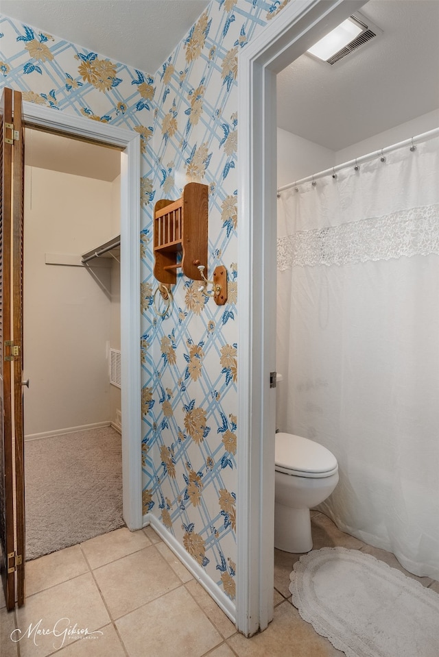 bathroom featuring toilet and tile flooring