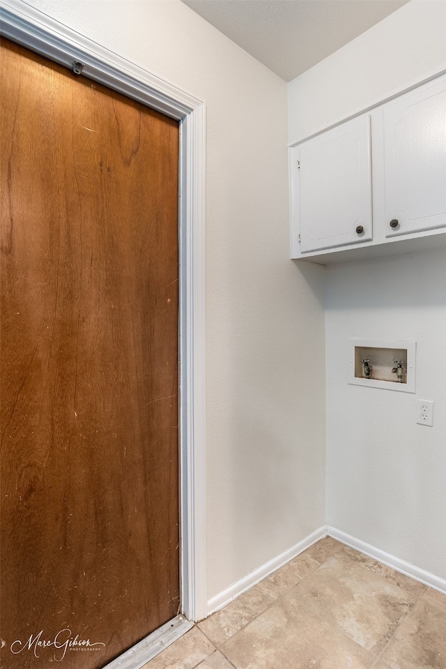 laundry area featuring cabinets, washer hookup, and light tile floors