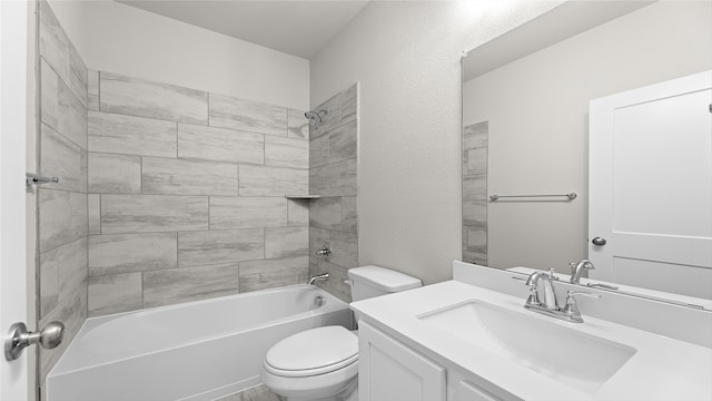 full bathroom featuring tiled shower / bath combo, vanity, and toilet