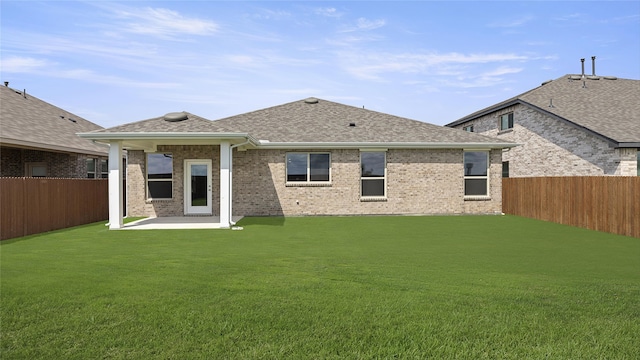 rear view of house with a lawn and a patio