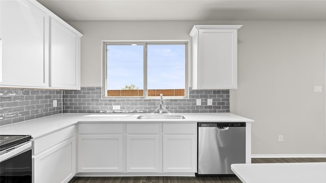 kitchen with appliances with stainless steel finishes, white cabinetry, tasteful backsplash, dark hardwood / wood-style flooring, and sink