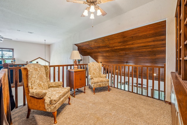 living area featuring a textured ceiling, carpet floors, ceiling fan, and lofted ceiling