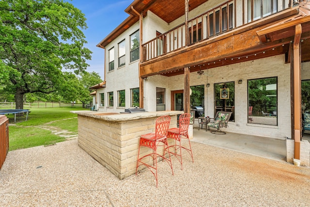 view of terrace featuring a balcony and exterior bar