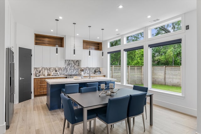 dining room with light hardwood / wood-style flooring and sink