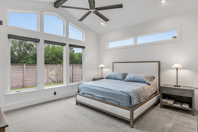 carpeted bedroom with high vaulted ceiling, multiple windows, ceiling fan, and beam ceiling