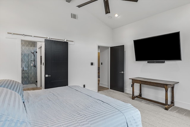 bedroom with high vaulted ceiling, a barn door, ensuite bath, ceiling fan, and wood-type flooring